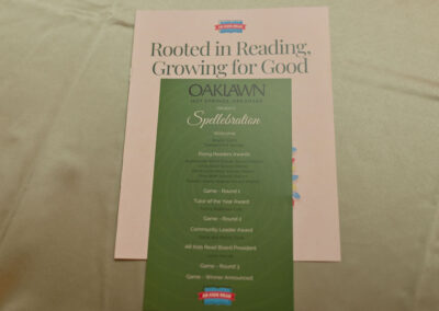 A booklet titled Rooted in Reading, Growing for Good features a green event program from Oaklawn in Hot Springs, Arkansas, listing activities like spelling games, awards, and a community leader award.